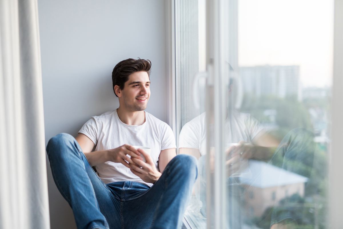 Mann mit Kaffee am Fenster